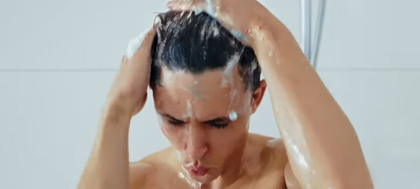 Junger Mann in der Dusche